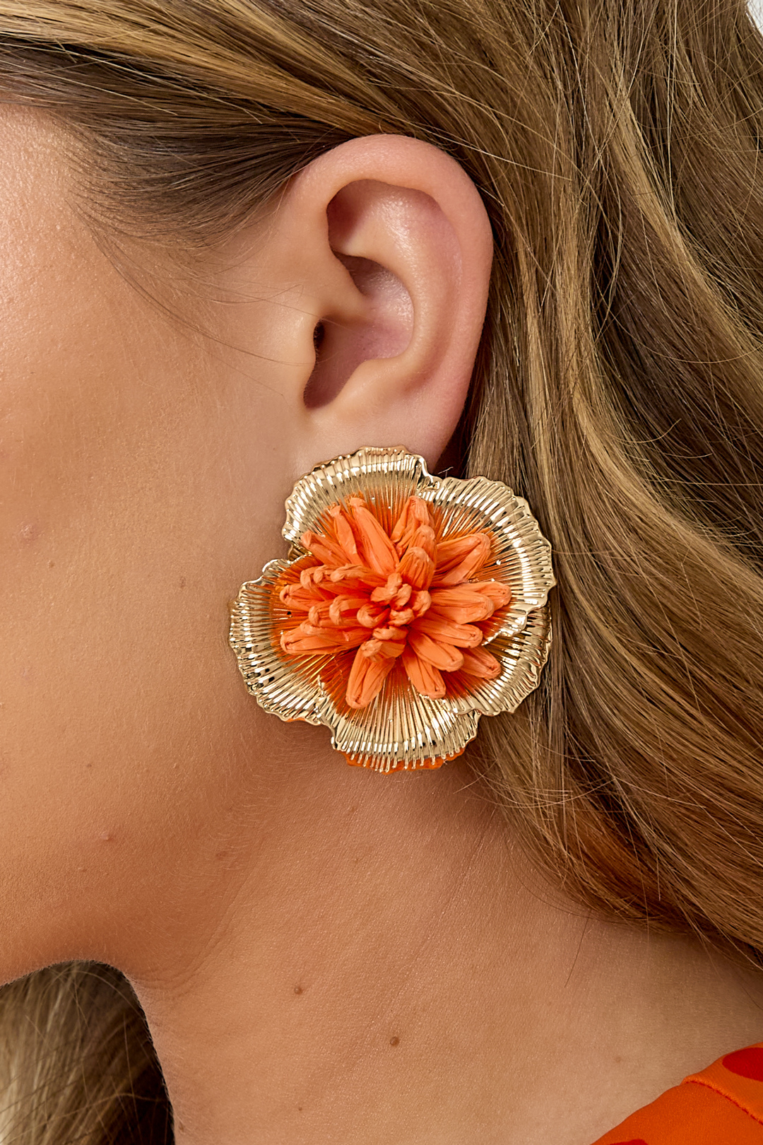 Boucles d'oreilles fleur raphia orange corail et métal doré portées