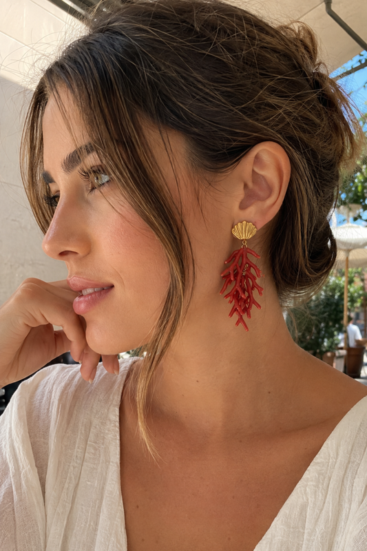 Femme portant les boucles d'oreilles branche de corail rouge et coquillage doré