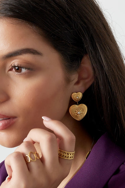 Boucles d'oreilles cœurs à strass portées à l'oreille