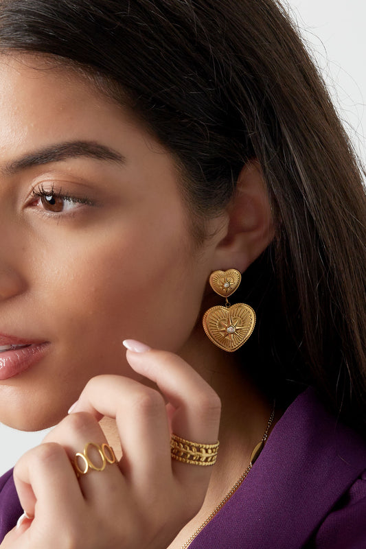 Boucles d'oreilles cœurs à strass portées à l'oreille
