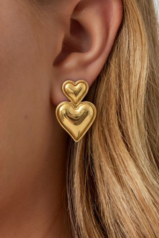 Boucles d'oreilles double cœur bombé doré portées à l'oreille