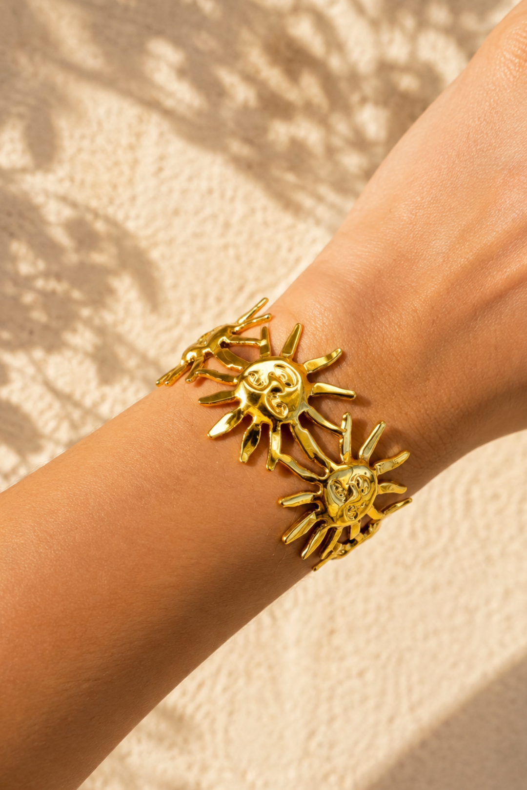 Bracelet jonc soleil doré porté au poignet dans une ambiance méditerranéenne ensoleillée