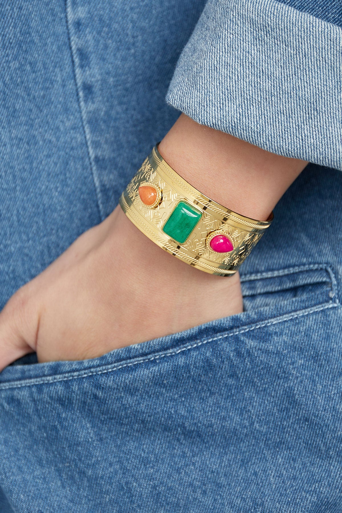Bracelet manchette dorée pierre rectangulaire porté au poignet